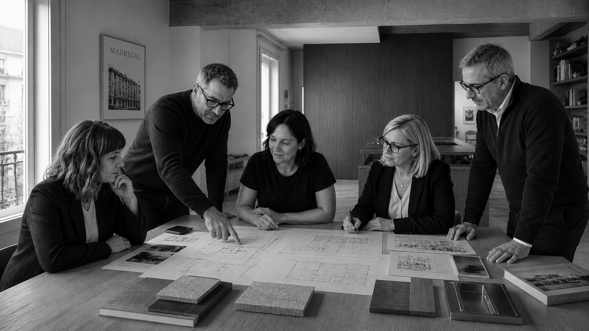 Equipo de ISOKO reunido alrededor de una mesa revisando planos, muestras de materiales y detalles constructivos en el estudio