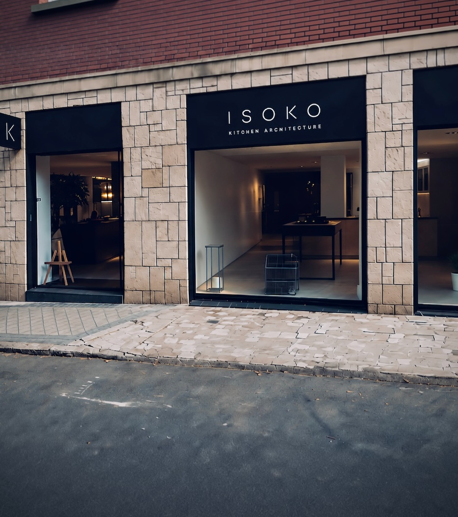 Fachada del estudio ISOKO en Madrid: escaparate central con el rótulo ISOKO Kitchen Architecture sobre fachada de piedra