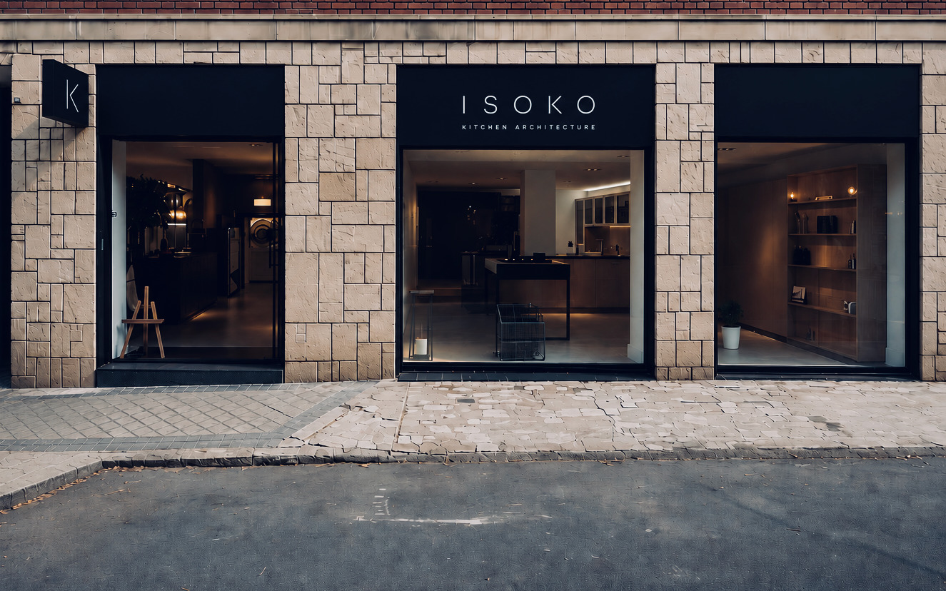 Fachada del estudio ISOKO en Madrid: tres escaparates con el rótulo ISOKO Kitchen Architecture sobre fachada de piedra y ladrillo