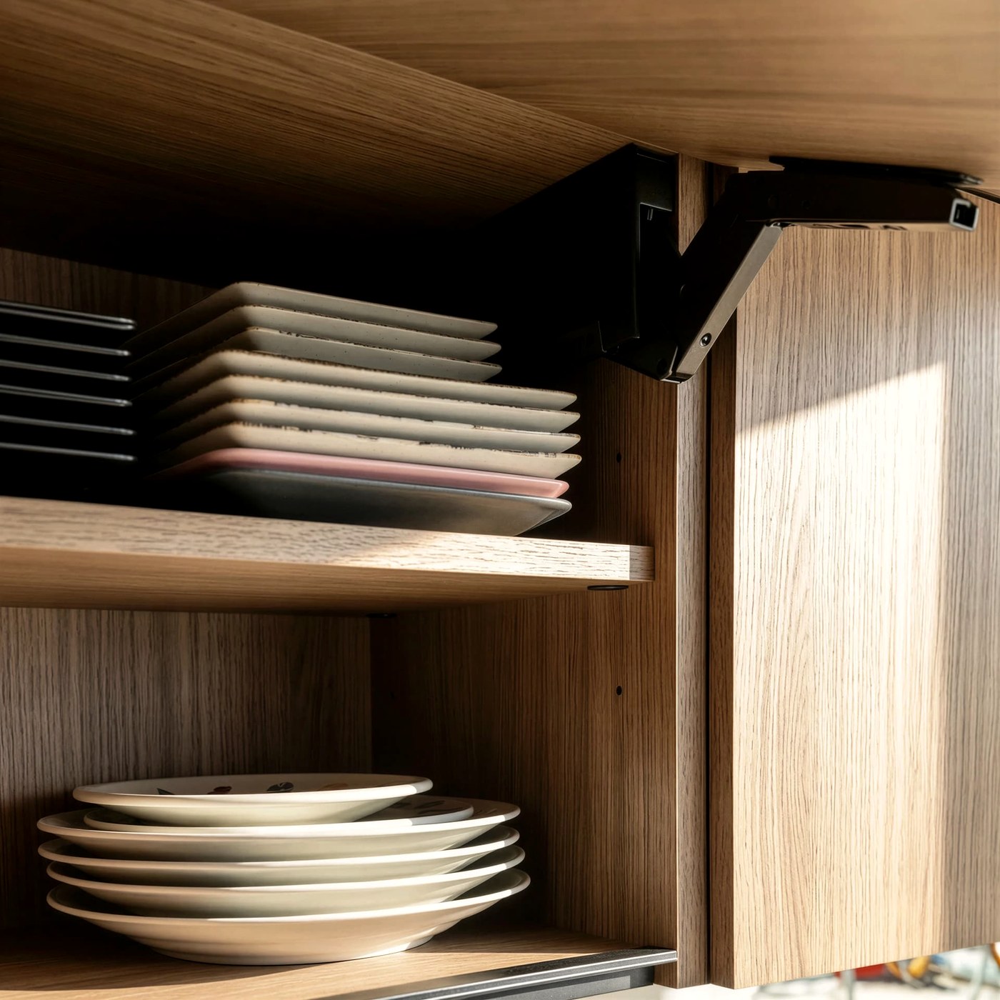 Interior de un mueble alto de madera clara con vajilla ordenada y herraje negro