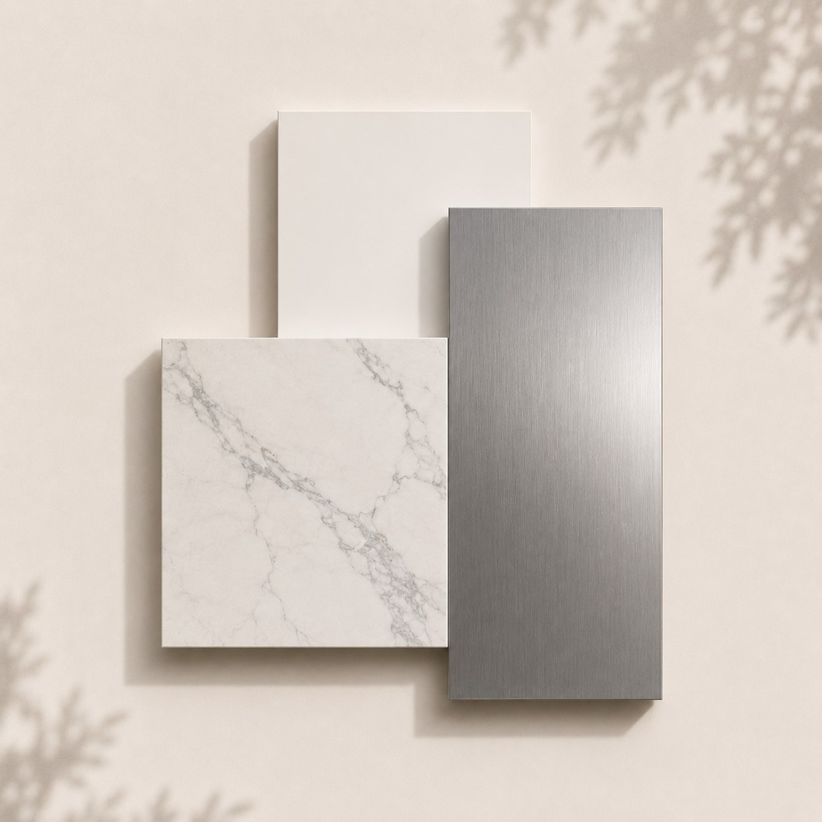 Composición de una muestra de lacado blanco seda, una plancha de porcelánico estatuario veteado y una lámina de acero inoxidable
