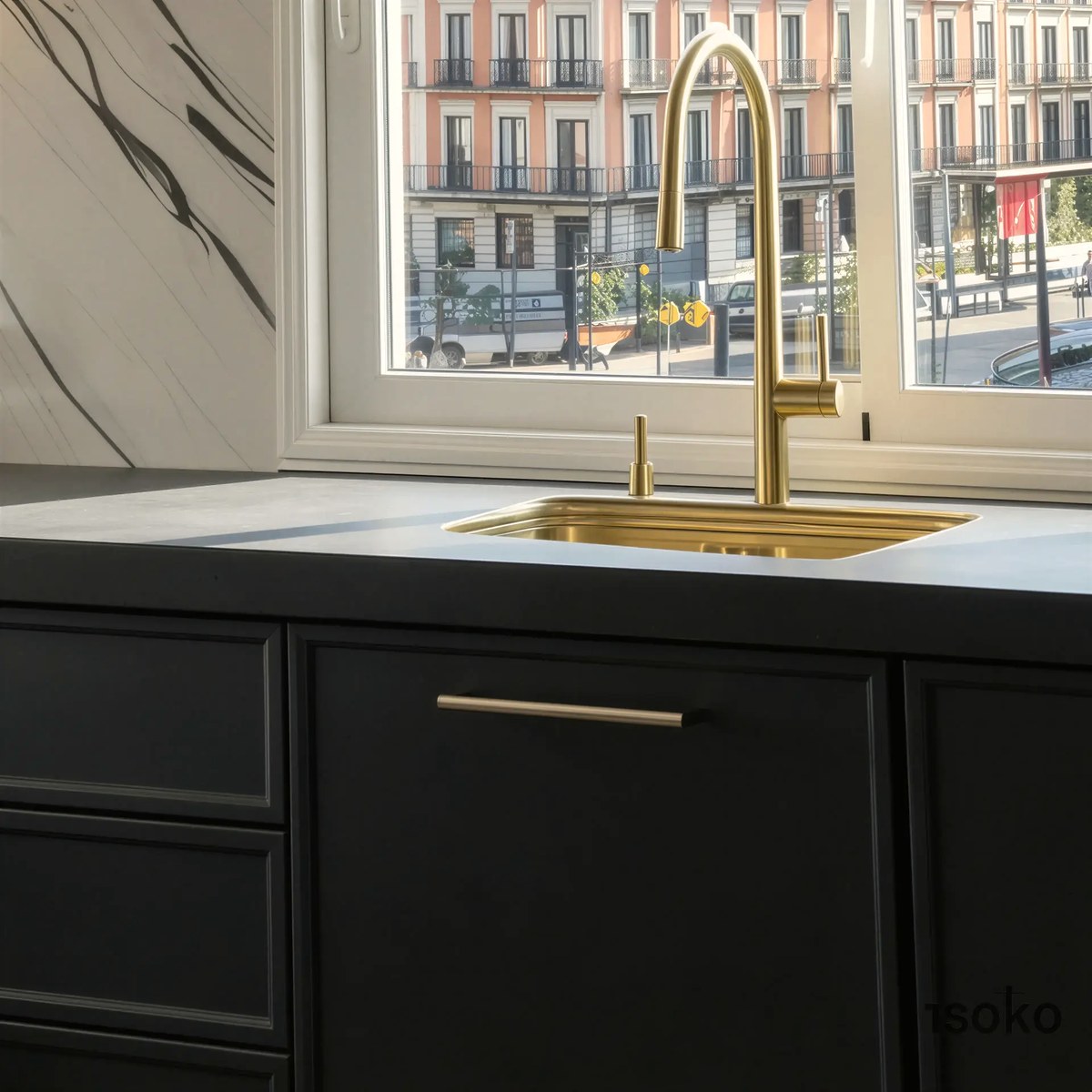 Grifería de latón cepillado sobre el fregadero, frente a la ventana